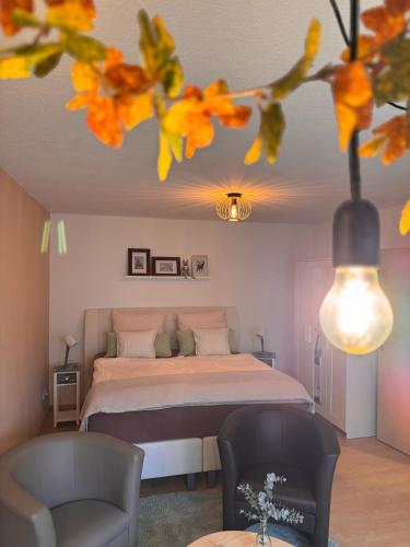 a bedroom with a bed and two chairs at Komfort-Apartment Mit Terrasse in Estenfeld