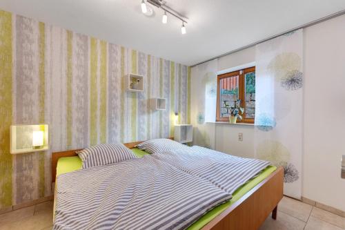 a bedroom with a large bed with striped sheets at Fewo im sonnigen Kaiserstuhl in Endingen