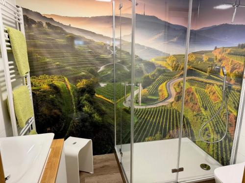 a bathroom with a shower with a painting of a mountain at Fewo im sonnigen Kaiserstuhl in Endingen