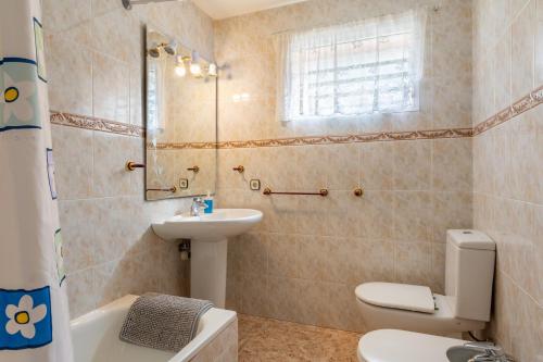 a bathroom with a toilet and a sink and a tub at Luna Azul in Sant Jordi