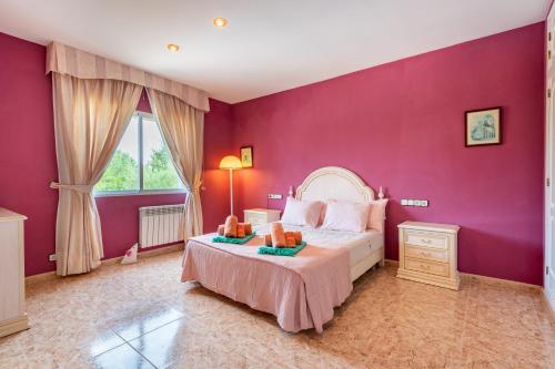a bedroom with a purple wall with a bed and a window at Luna Azul in Sant Jordi