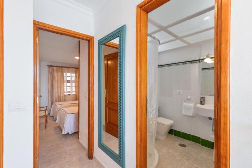 a bathroom with a toilet and a sink and a mirror at Playa Delphin 306 in Puerto Naos