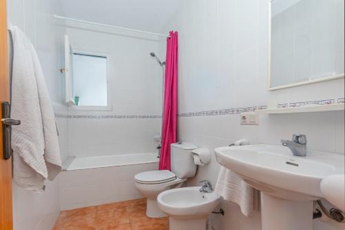a white bathroom with a toilet and a sink at White sands 613 in Arenal d'en Castell