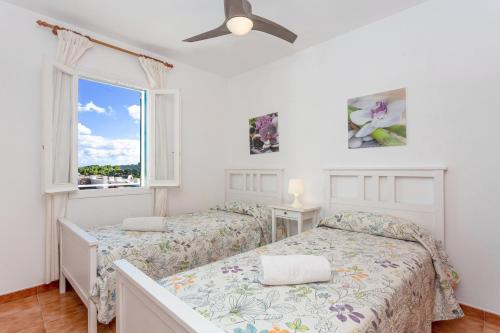 a bedroom with two beds and a window at White sands 613 in Arenal d'en Castell