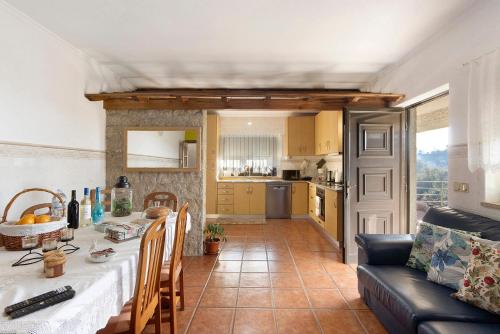 a kitchen and living room with a table and a couch at Casa De Santo Amaro in Carrazedo