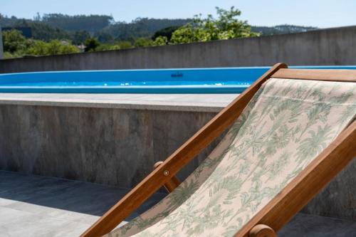 a wooden bed next to a swimming pool at Casa De Santo Amaro in Carrazedo