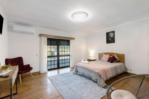a bedroom with a bed and a table and chairs at Casa De Santo Amaro in Carrazedo
