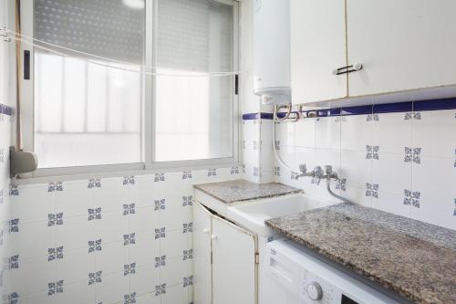 eine Küche mit Spüle und Fenster in der Unterkunft Ca Llaurí in Daimús
