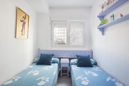 ein Zimmer mit zwei Betten, einem Tisch und einem Fenster in der Unterkunft Ca Llaurí in Daimús