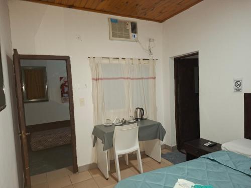 a room with a table and a room with a bed at Hostal AMALAYA in Salta