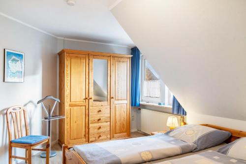 a bedroom with a bed and a wooden cabinet at Heidis Fewo in Hohenkirchen