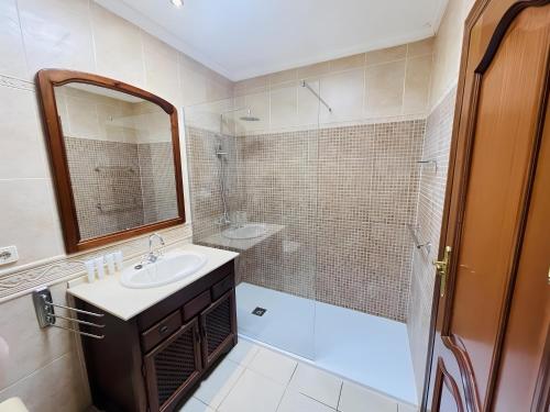 a bathroom with a sink and a shower and a mirror at Villa Gauda in Lanzarote