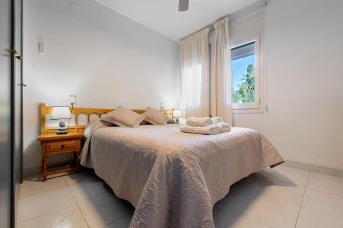 a white bedroom with a bed with a window at La Terraza in Riumar