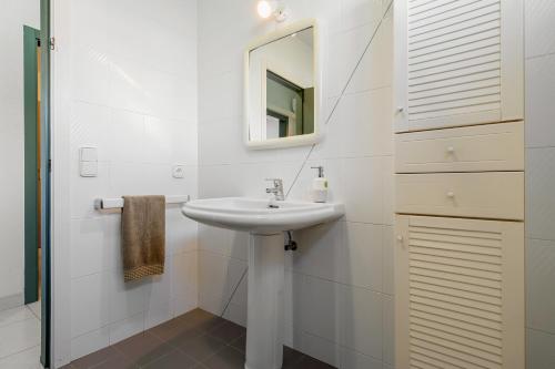 a white bathroom with a sink and a mirror at La Terraza in Riumar
