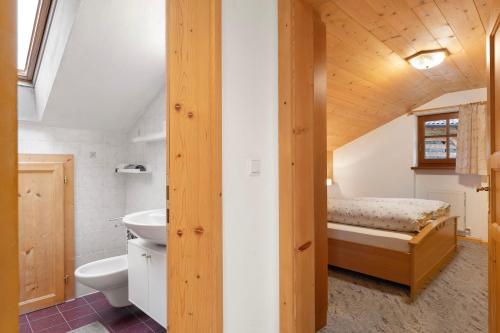 a bathroom with a sink and a bed in a room at Stampferhof in Völs am Schlern