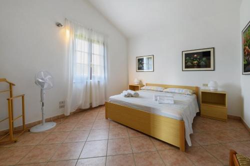 a bedroom with a bed with a fan and a window at Residenza Le Paolette con piscina in Padenghe sul Garda