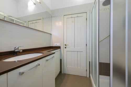 a bathroom with a sink and a white door at Residenza Le Paolette con piscina in Padenghe sul Garda