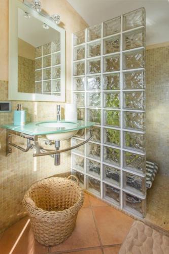 a bathroom with a sink and a glass wall at Es Tarongers in Sóller