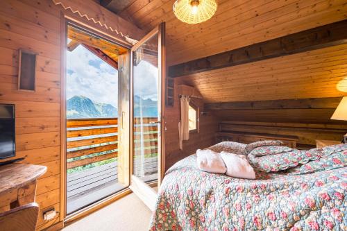 a bedroom with a bed and a large window at Chalet Farapreu in Manigod