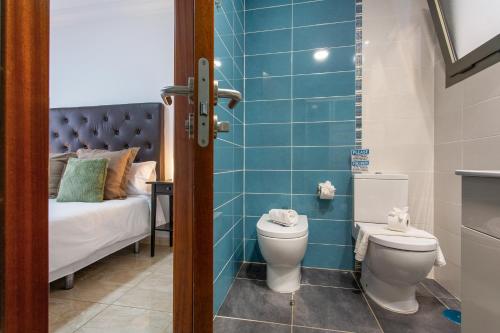 a bathroom with a toilet and a bed at Apartamento Rolycar 204 in Icod de los Vinos