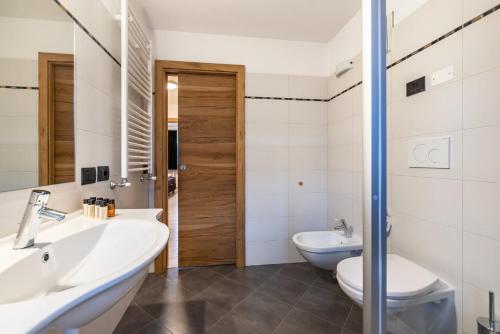 a bathroom with two sinks and a toilet at Appartamento Tobià in Pozza di Fassa