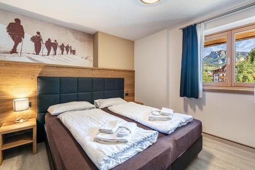 a bedroom with a bed with two towels on it at Appartamento Tobià in Pozza di Fassa