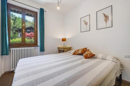 a bedroom with a large bed with a window at di Pastei 13 in Ledro