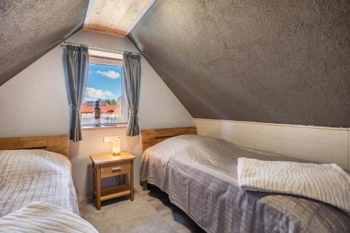 a attic bedroom with two beds and a window at Ferien mit Hund Blomberg Ostfriesl in Blomberg