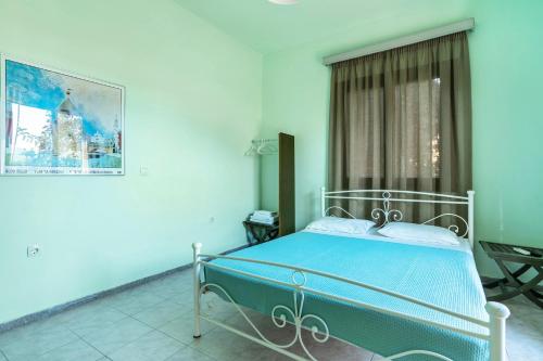 a blue bedroom with a bed and a window at Old Boat double studio 4 in Nikiana