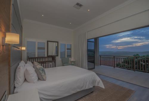 a bedroom with a large bed and a balcony at 8 Tinderwood Lane in Ballito