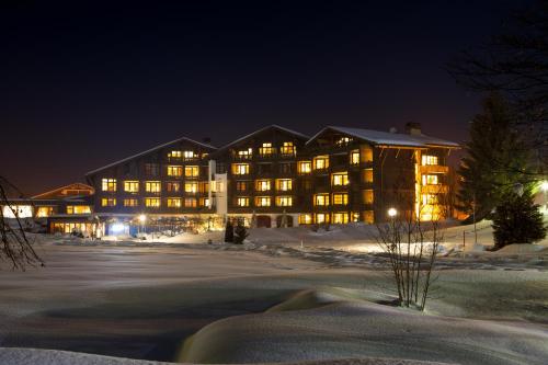 a large building in the snow at night at Parkhotel Oberstaufen in Oberstaufen