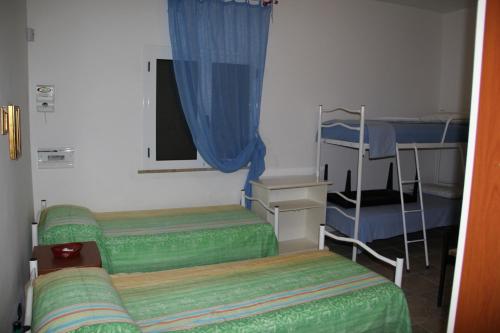 トッレ・ラピッロにあるVilla Rosariaの二段ベッド2台、窓が備わる小さな客室です。