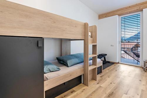 a bedroom with bunk beds and a large window at Penthouse - Apartment Venosta in Naturno