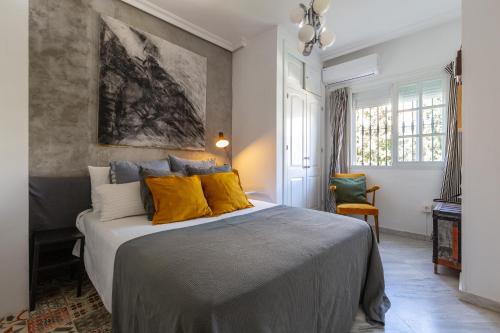 a bedroom with a large bed with yellow pillows at Cute apartment oceanfront in Benalmádena