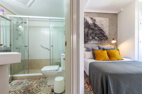 a bedroom with a bed and a shower and a toilet at Cute apartment oceanfront in Benalmádena