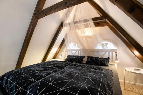 a bedroom with a black bed in the attic at Hyggelig Am Deich - Ockholm in Ockholm