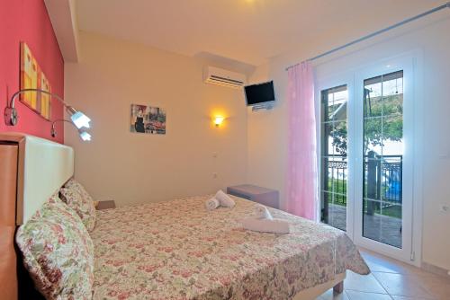 a bedroom with a bed and a large window at Villa Pepy Studio 3 in Mesongi