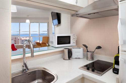 a kitchen with a sink and a microwave at Seaviews A61 in Torrox Costa