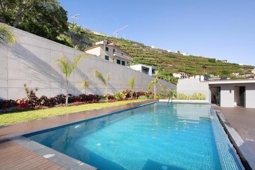 a swimming pool in front of a building at Casa Castanheta in Câmara de Lobos