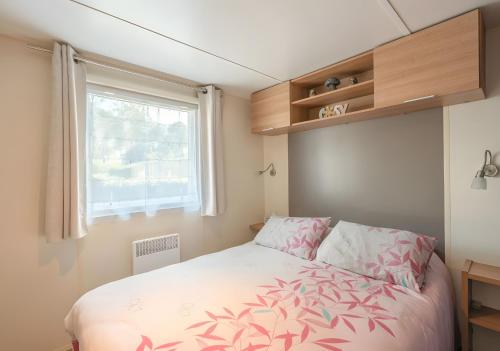 a small bedroom with a bed and a window at Mh324 La Tremblade in La Tremblade