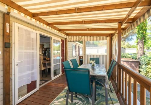 a patio with a table and chairs on a deck at Mh324 La Tremblade in La Tremblade