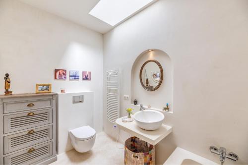 a bathroom with a sink and a toilet and a mirror at Casa De La Mar 19 in Colonia de Sant Pere