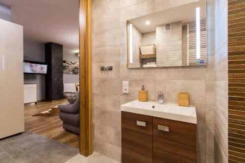 une salle de bain avec un lavabo et un miroir dans l'établissement Apartamenty pod Giewontem SPA, à Zakopane