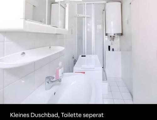 a white bathroom with a sink and a toilet at Fewo Forchheim in Forchheim