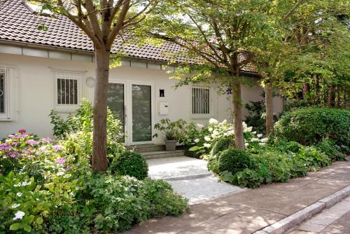 a house with trees and flowers in front of it at Secret Garden in Müllheim