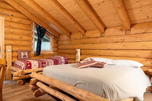 a bedroom with two beds in a log cabin at Agritur Cazzuffi in Peio
