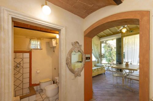 a bathroom with a toilet and a mirror on the wall at San Giovanni Residence in Peccioli