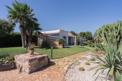 a house with a garden with cacti and a stone pathway at Tramonto A Nordovest in Favignana