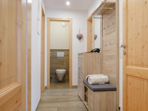 ein Badezimmer mit Toilette und Holztür in der Unterkunft Ferienwohnung Eulennest in Wolfach