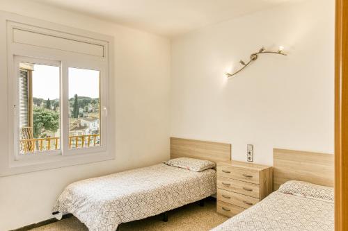 a bedroom with two beds and a window at Riells Platja in L'Escala